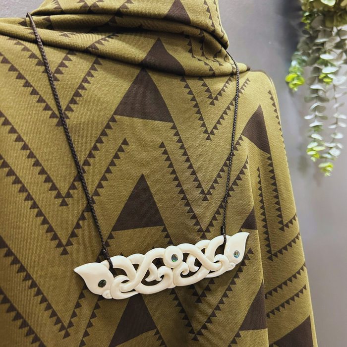 Manaia Bone Neckalce and Tukemata Poncho in Green at Maori Pakihi Ahu boutique